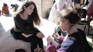Una chica observa el trabajo de su compañera en una jornada soleada en el Monumento este sábado. (Alan Monzón/Rosario3.com)