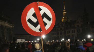 Un activista del movimiento islamófobo sujeta un cartel con una cruz esvástica tachada durante la manifestación de este lunes por la noche. (EFE)