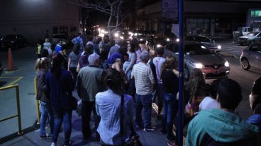 Muchas personas en las paradas de colectivos y en esquinas con algo de luz.