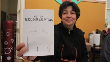 Una autoridad de mesa muestra uno de los sobres donde la gente colocaba las boletas. (Rosario3.com)