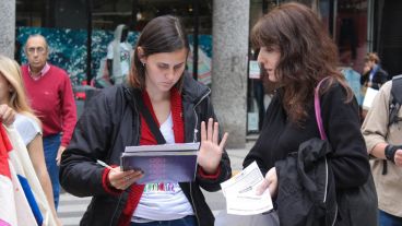 Una de las integrantes del movimiento encuestando a una mujer en la esquina de Córdoba y Paraguay. (Rosario3.com)