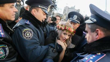 Varios policías detienen a una mujer durante la manifestación. (EFE)