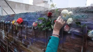 Una mujer pone unas flores en las cruces que recuerdan a las víctimas. (Alan Monzón/Rosario3.com)