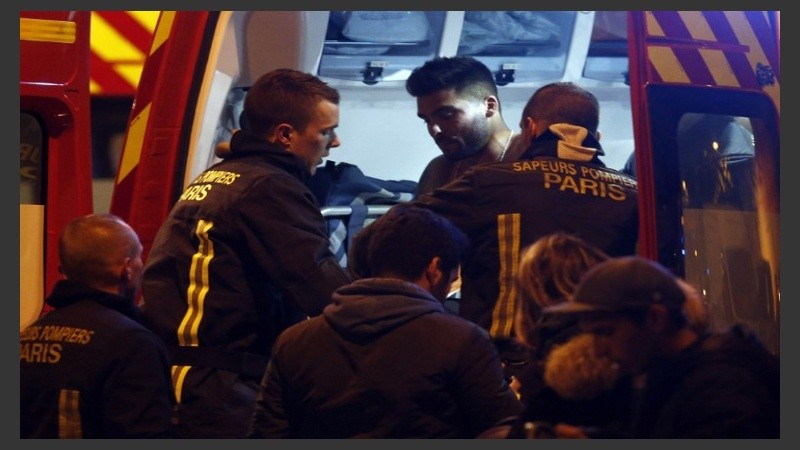 Un hombre herido asistido por bomberos, junto al Estadio de Francia, donde tres bombas estallaron en el norte de París.