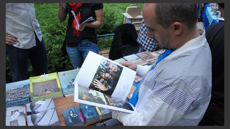 Un hombre observa un libro de fotografía este viernes por la tarde. (Alan Monzón/Rosario3.com)