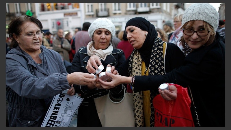 Mujeres encienden las velas para recordar a las víctimas del atentado de París en Bruselas. (EFE)