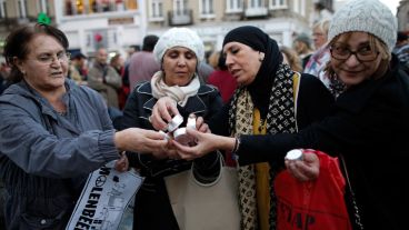 Mujeres encienden las velas para recordar a las víctimas del atentado de París en Bruselas. (EFE)