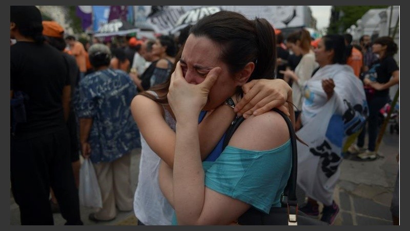 Dos militantes se abrazan y lloran. 