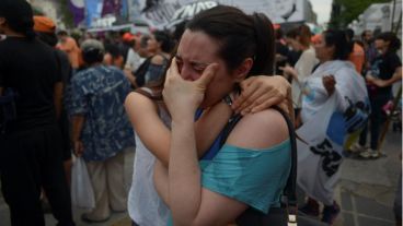 Dos militantes se abrazan y lloran.