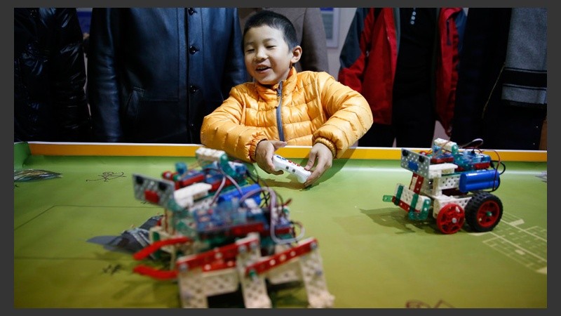 Un niño juega y se divierte con un robot teledirigido. (EFE)