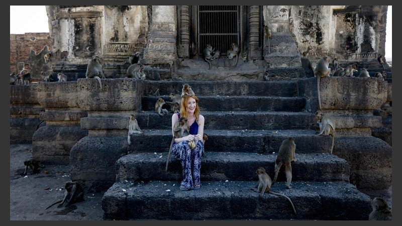 Una joven posa con los animales en el templo  Phra Prang Sam Yod. (EFE)
