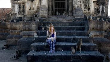 Una joven posa con los animales en el templo  Phra Prang Sam Yod. (EFE)