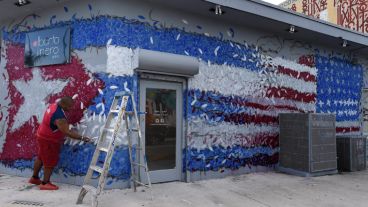 El artista gráfico Michelle Maeral trabaja en un mural en referencia al acercamiento de este año entre Cuba y Estados Unidos (EFE)