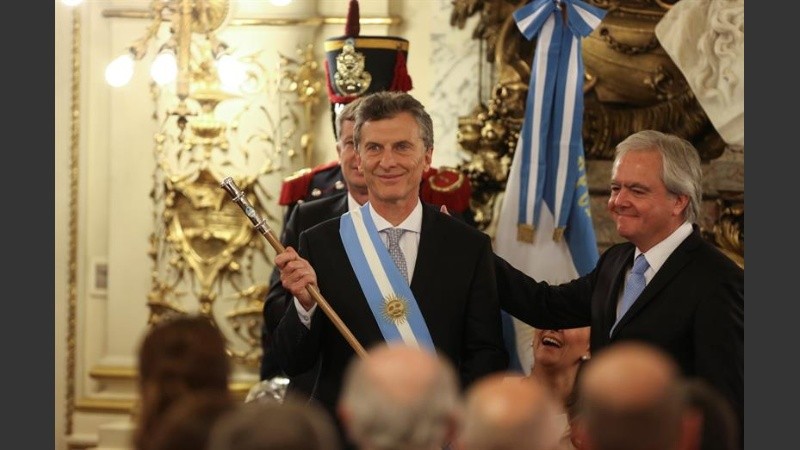 El presidente Macri embestido con el bastón y la banda presidencial