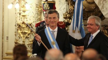 El presidente Macri embestido con el bastón y la banda presidencial