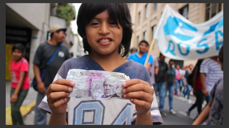 Un joven muestra un billete de 50 pesos falso durante la movilización este martes. (Rosario3.com)