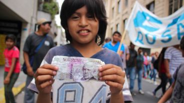 Un joven muestra un billete de 50 pesos falso durante la movilización este martes. (Rosario3.com)