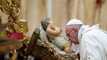 El Papa besando los pies de la imagen del Niño Jesús. (EFE)