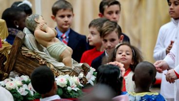Niños rodeando la imagen del Niño Jesús en el Vaticano. (EFE)
