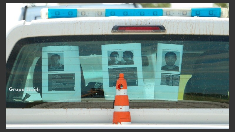 Fotografías de cada uno de los prófugos pegados en los patrulleros. (Alan Monzón/Rosario3.com)