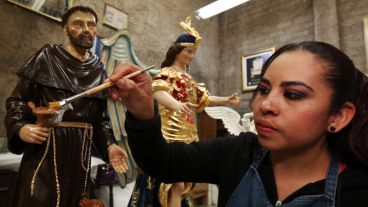 Una mujer trabaja en la elaboración de los muebles y accesorios que el papa Francisco utilizará en su próxima visita a México. (EFE)