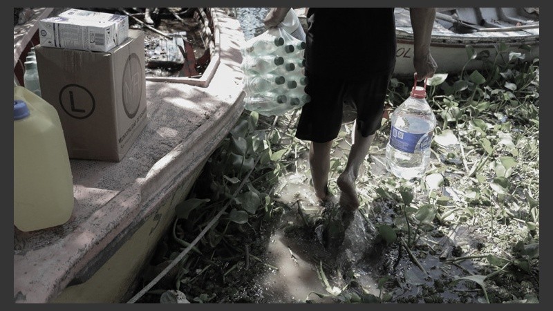Pies descalzos al agua. La ayuda llegó del otro lado del río. (Alan Monzón/Rosario3.com)