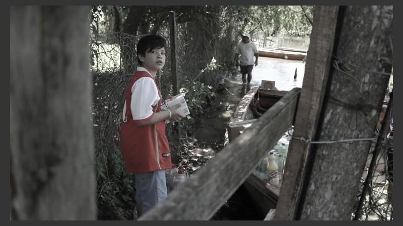 Un joven colaborando a cargar las donaciones a las diversas lanchas. (Alan Monzón/Rosario3.com)