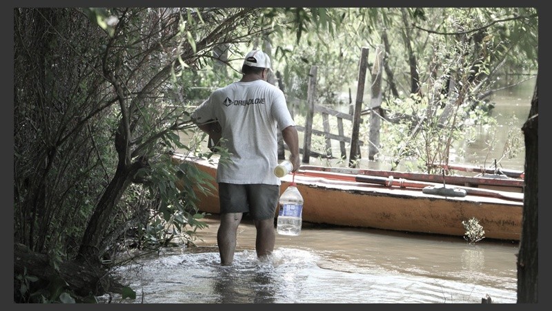 Un hombre lleva parte de las donaciones a su embarcación. Son unas 30 familias las que viven en El Espinillo. (Alan Monzón/Rosario3.com)