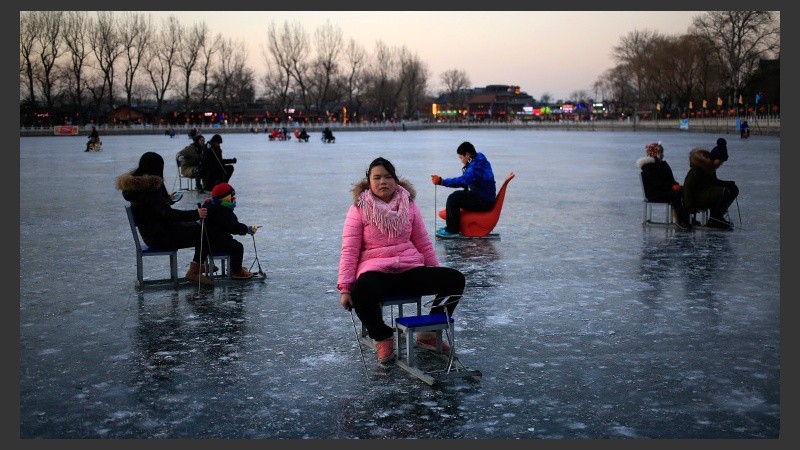 Varias personas disfrutando del lago en Pekín. (EFE)