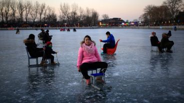 Varias personas disfrutando del lago en Pekín. (EFE)