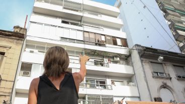 Una mujer se comunica con señas y gritos con su pariente en el edificio.