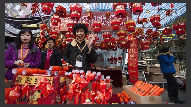 Varias mujeres chinas posan junto a un puesto de adornos de la Feria del Año Nuevo Lunar en el Parque Victoria de Hong Kong. (EFE)