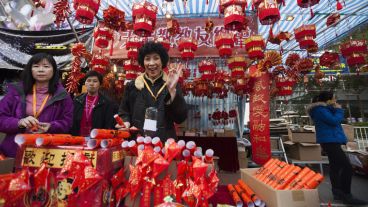 Varias mujeres chinas posan junto a un puesto de adornos de la Feria del Año Nuevo Lunar en el Parque Victoria de Hong Kong. (EFE)