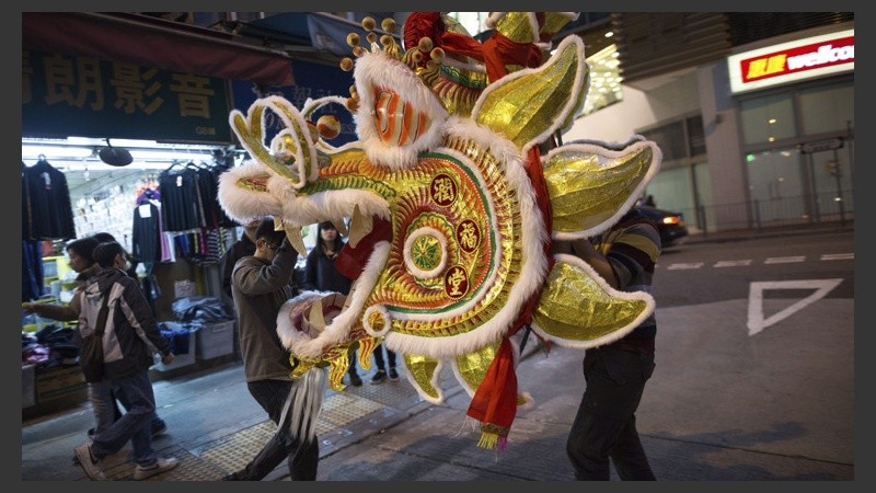 Artesanos chinos trasportando una obra realizada con bambú y papel en los preparativos para Año Nuevo en Hong Kong. (EFE)