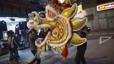 Artesanos chinos trasportando una obra realizada con bambú y papel en los preparativos para Año Nuevo en Hong Kong. (EFE)