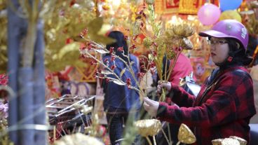 Una mujer vende decoraciones en un puesto callejero en Hanoi, Vietnam. El próximo lunes se festejará un Nuevo Año Chino. (EFE)