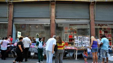 Peatones observan la mercadería pegada a una tradicional tienda de la ciudad.