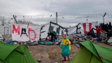 Refugiados caminan por el barro en un campamento cerca de Idomeni mientras esperan para cruzar la frontera con Macedonia.