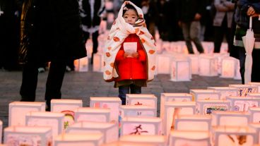 Una niña observa varias linternas de papel durante una ceremonia en conmemoración de las víctimas del terremoto y posterior tsunami.