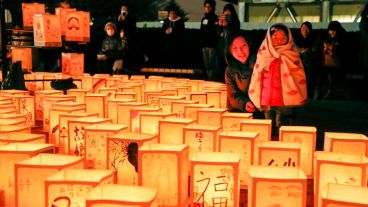 Una mujer y su hija observan varias linternas de papel durante una ceremonia en conmemoración de las víctimas del terremoto y posterior tsunami.