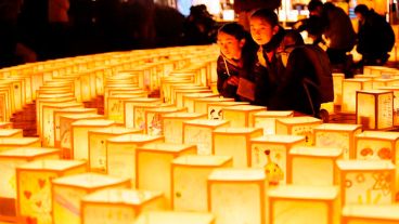 Las jóvenes Fuuka y Asena Takakeda observan varias linternas de papel durante una ceremonia en conmemoración de las víctimas del terremoto y posterior tsunami.