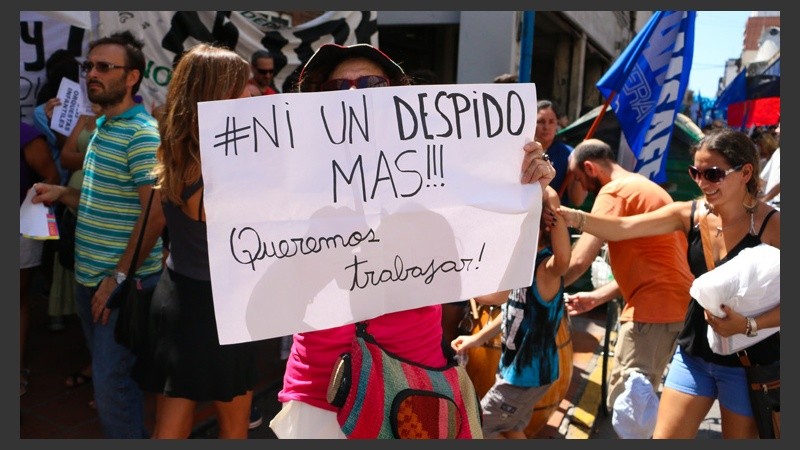 Una señora sostiene un cartel: 