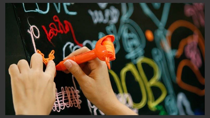 Una joven interacciona con un cuadro expuesto en la muestra 