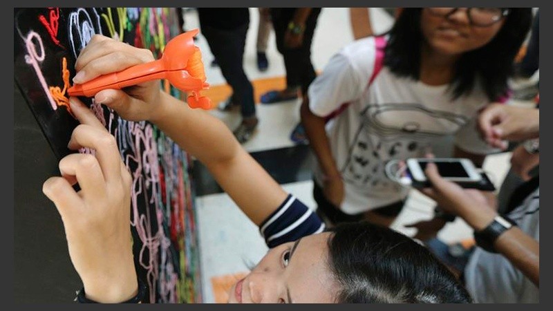 Una joven interacciona con un cuadro expuesto en la muestra 