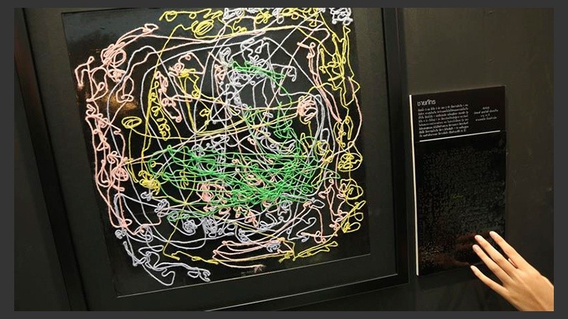 Una joven interacciona con un cuadro expuesto en la muestra 
