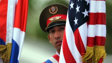 Un soldado cubano sostiene una bandera estadounidense durante el acto oficial este lunes. (EFE)