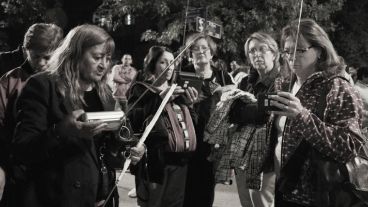 Mujeres sintonizando Radio 2 para oír las palabras del padre Ignacio durante la procesión. (Alan Monzón/Rosario3.com)