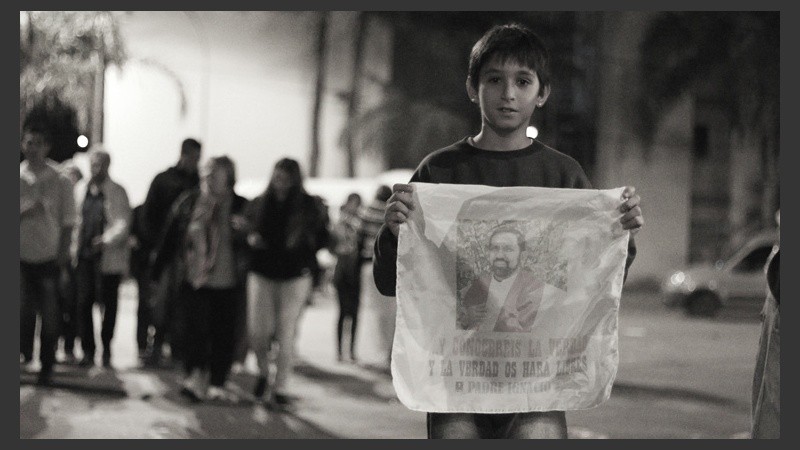 Un joven sostiene un pañuelo con la imagen del padre Ignacio. (Alan Monzón/Rosario3.com)