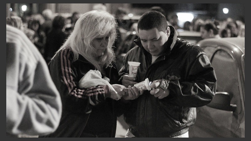 Dos personas intentan prender una vela. (Alan Monzón/Rosario3.com)