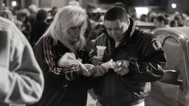 Dos personas intentan prender una vela. (Alan Monzón/Rosario3.com)